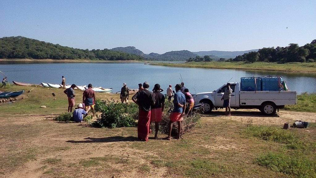 Fishers and a Divron pickup gathered on the reservoir shore at a harvest