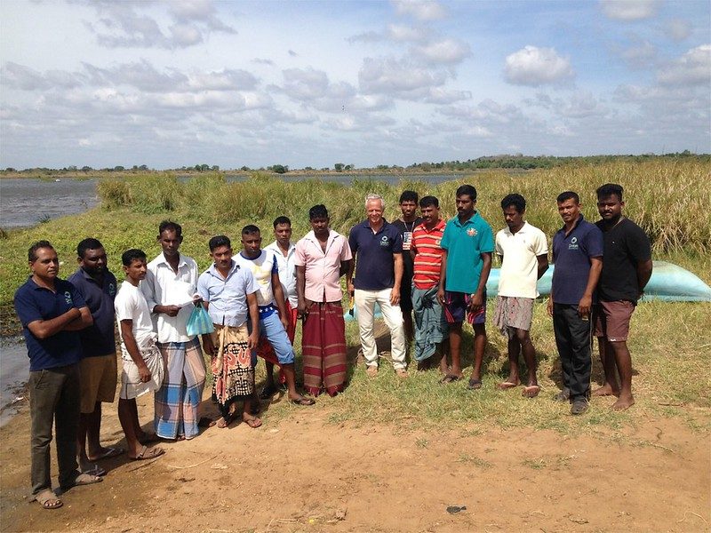 Divron staff and a partner fisher community photographed together on the reservoir shore
